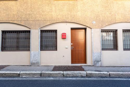 a building with a brown door and three windows at La casa di Aurora in Pavia