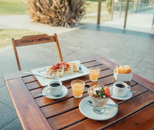 a table with a tray of food and two cups of coffee at Chacras de Sierra in Sierra de los Padres