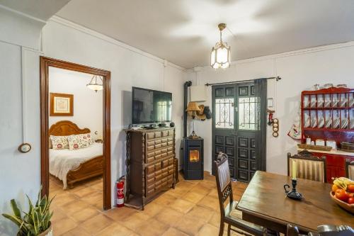 a room with a dining table and a bedroom at Cubo's Cortijo La Olivera in Antequera