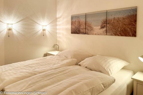 a white bed with two pillows in a bedroom at Luv und Lee in Schilksee