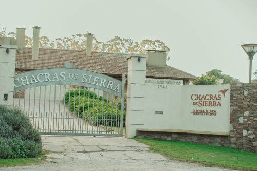 a gate to a building with a sign on it at Chacras de Sierra in Sierra de los Padres
