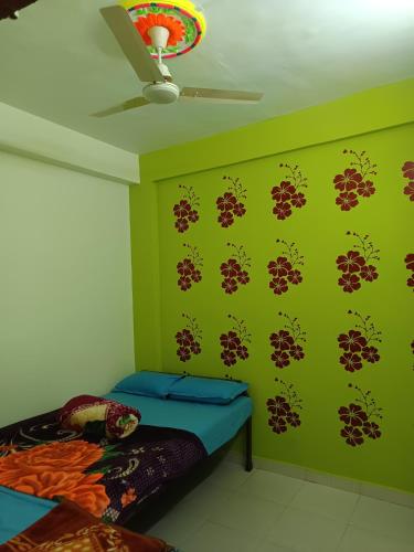 a bedroom with green walls with a bed and a ceiling at Swami Inn Lodging in Trimbak