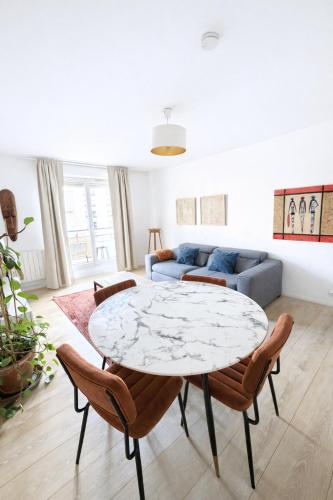 a living room with a table and a couch at Charme et Douceur By UTA HOUSE in Saint-Denis