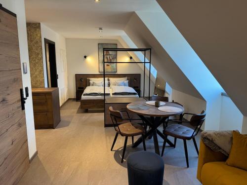 a bedroom with a bed and a table and chairs at Parzivita Suites in Wolframs-Eschenbach
