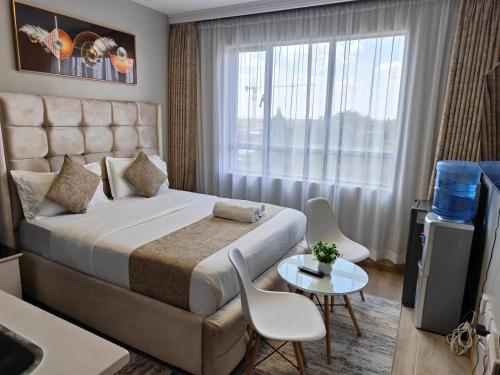 a hotel room with a large bed and a window at Jkia Airport 24 Hours Transit studio next 67hotel in Nairobi