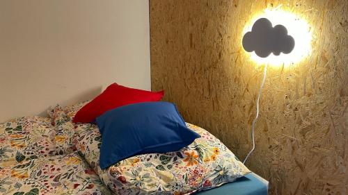 a bed with two pillows and a cloud on the wall at Das Blaue Haus - jetzt mit Sauna in Pirmasens