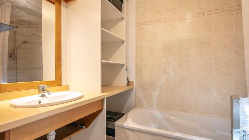 a bathroom with a sink and a bath tub at Le Birdie NI105 - ST2 in Giez