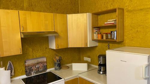 a kitchen with wooden cabinets and a white refrigerator at Das Blaue Haus - jetzt mit Sauna in Pirmasens