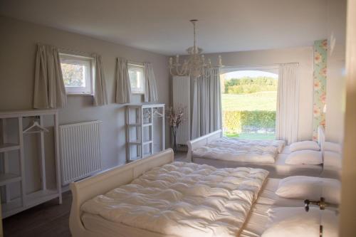 a bedroom with three beds in front of a window at 'Op de Borgt' met Finse Grill Kota in Wellen
