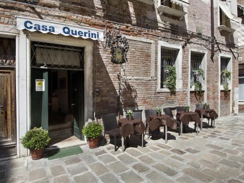 a row of tables and chairs outside of a building at Locanda Casa Querini in Venice