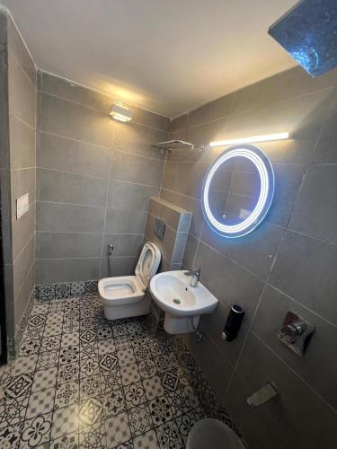 a bathroom with a white toilet and a sink at Hotel Enigma in Indore