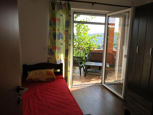 een slaapkamer met een bed en een glazen schuifdeur bij Apartments Victoriya in Sutomore