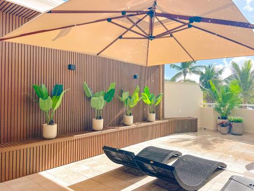un grande ombrellone appoggiato su un patio con piante di Ocean Pearl Elegant studio steps from the beach a Orient Bay