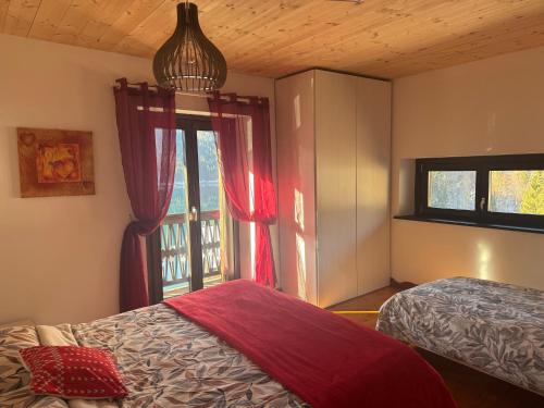 a bedroom with a bed and a window at Lago Maina Appartamenti in Sauris