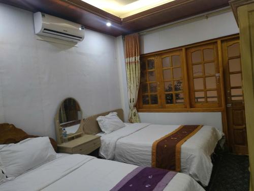 a hotel room with two beds and a mirror at SUN Homestay sa pa in Sapa