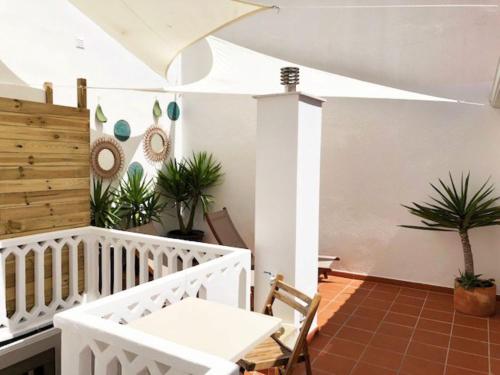 a white room with plants and a white table at Villa 2 Quartos by WOT Lodge Soul in Ericeira