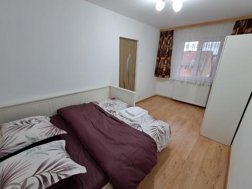 a bedroom with a large bed and a small room at "NIB's apartment" in Caransebeş