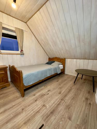 a bedroom with a bed and a table in a room at Grey House Istebna in Istebna