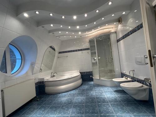 a bathroom with two toilets and a tub and a sink at Apartament Krzemienna in Bielsko-Biała
