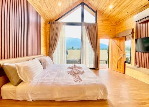 a bedroom with a large bed with a large window at Nordic pool villa huahin6 in HHQ