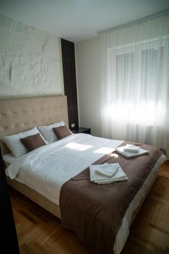 a bedroom with a large bed with two towels on it at Nedodjija apartman in Leskovac