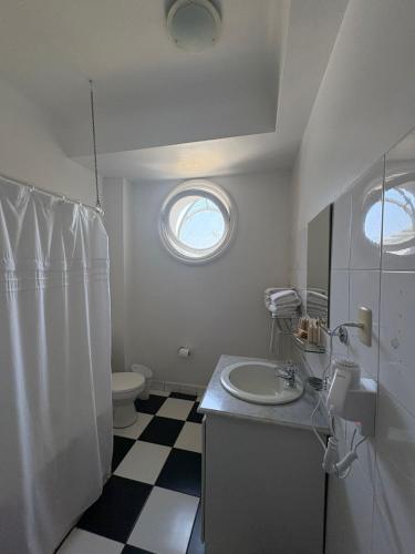 a bathroom with a sink and a toilet and a window at Resort Termas de Panimávida - Hotel & Spa in Panimávida