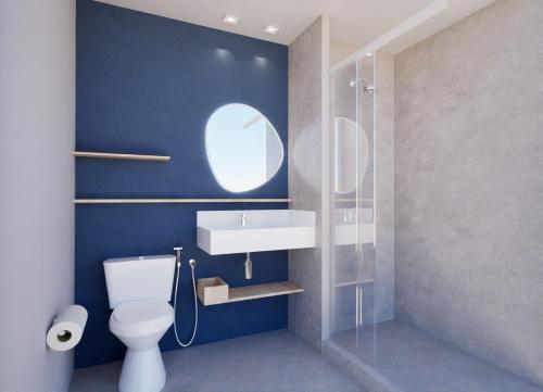 a bathroom with a white toilet and a sink at Matiz Barão Geraldo Express Hotel in Campinas