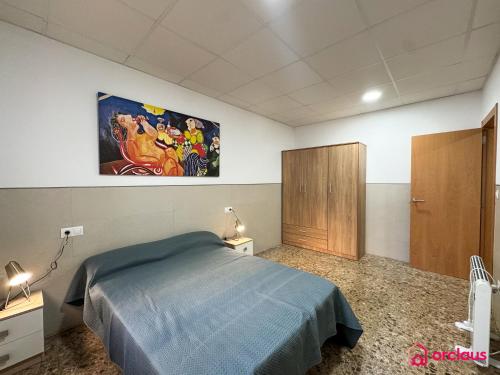 a bedroom with a bed and a painting on the wall at El Piso Bajo in San Juan de Moró