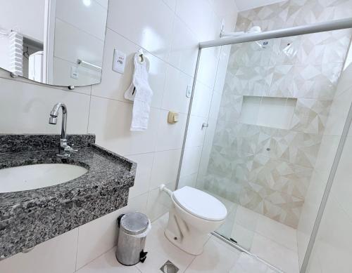 a bathroom with a toilet and a sink and a shower at Pousada Acalanto in Aracaju