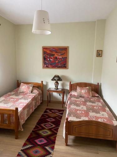 una camera da letto con due letti e un tavolo con una lampada di Comfy Spacious Apartment a Tirana