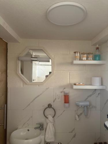 a bathroom with a sink and a mirror at Windy Nook - The Contemporary Tiny Home in Saint Philip