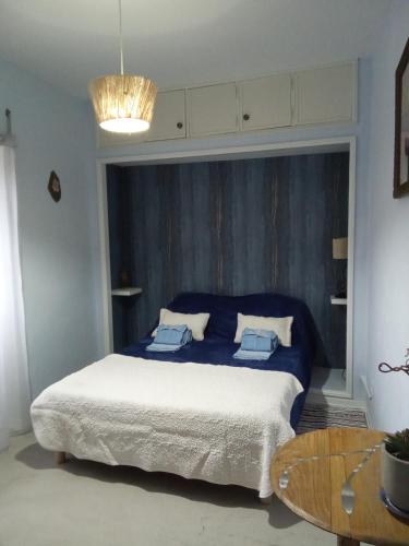a bedroom with a bed with blue sheets and a table at casa thocamalu's in Covelo