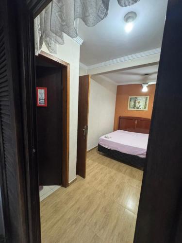 a bedroom with a bed and a door to a room at Predinho do Guaratuba in Guaratuba