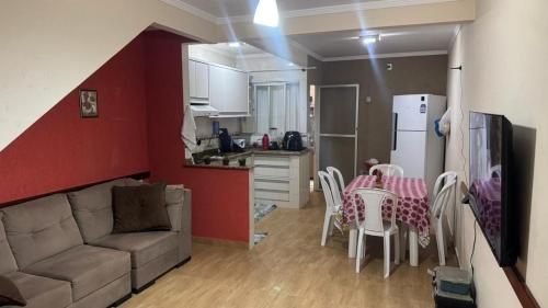 a living room with a couch and a table and a kitchen at Predinho do Guaratuba in Guaratuba