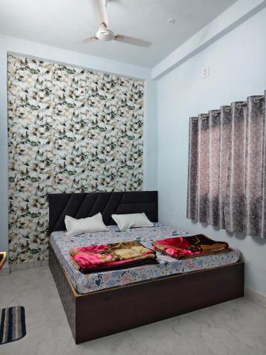 a bedroom with a bed with a large wall at Shiv Lehri Homestay in Ujjain