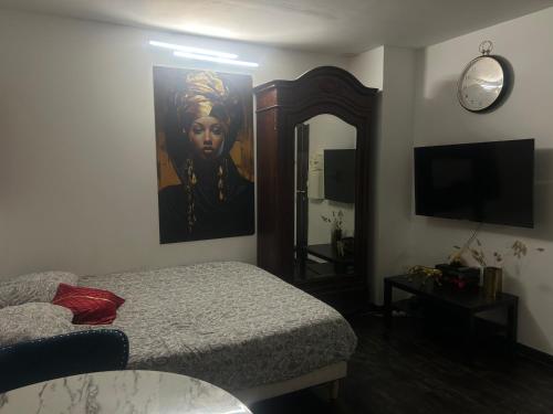 a bedroom with a bed and a painting of a woman at Résidence P&C Studio calme & cosy proche Paris - Neuilly-sur-Marne in Neuilly-sur-Marne