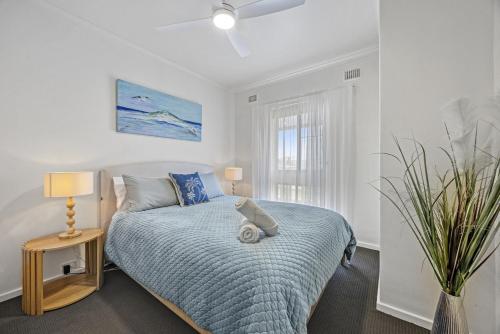 a bedroom with a bed and a table and a window at Sunset Seas in West Beach in West Beach