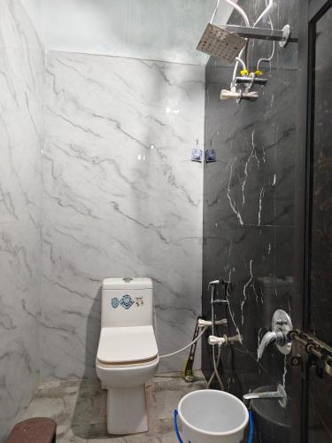 a bathroom with a white toilet and a sink at Shiv Lehri Homestay in Ujjain