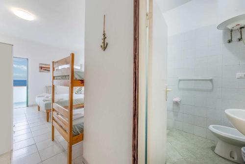 a bathroom with a sink and a toilet and a bed at Hotel Le Ghiaie in Portoferraio