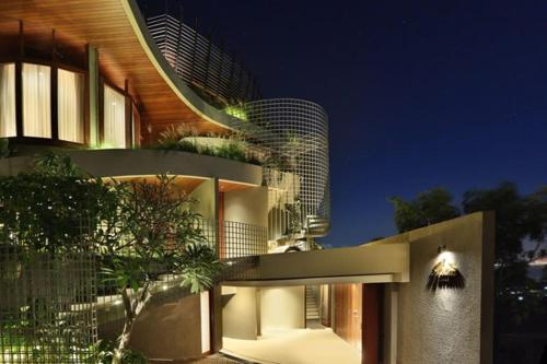 a large building with a building with a tree at Dacolina House Jimbaran in Jimbaran