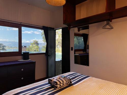 a bedroom with a bed and a large window at Garden Gathering Room in San Lucas Tolimán