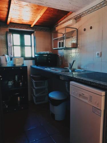 a kitchen with a sink and a counter top at Quinta do Sardanito de Tras in Zambujeira do Mar