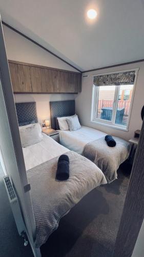 a bedroom with two beds and a window at Blue Water Retreats in Carnforth