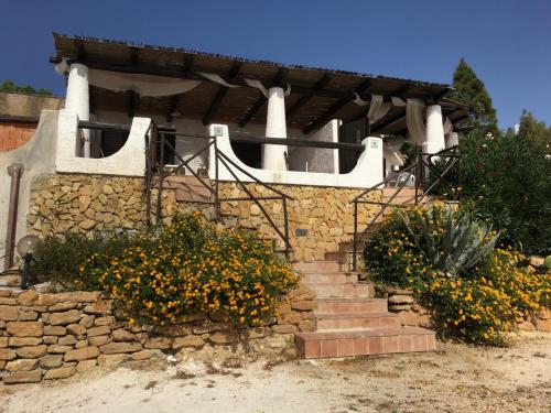 a house with a stone wall with stairs and flowers at Villa Sciacca Lumia LUNA in Sciacca