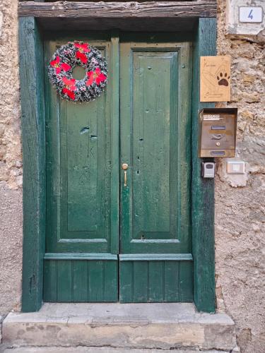 a green door with a wreath on it at I Pelosetti in Calalzo