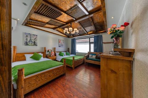 a bedroom with a bed with green sheets and a couch at 古城区瑾琳客栈 in Lijiang