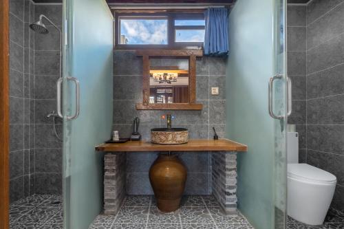 a bathroom with a sink and a toilet and a mirror at 古城区瑾琳客栈 in Lijiang