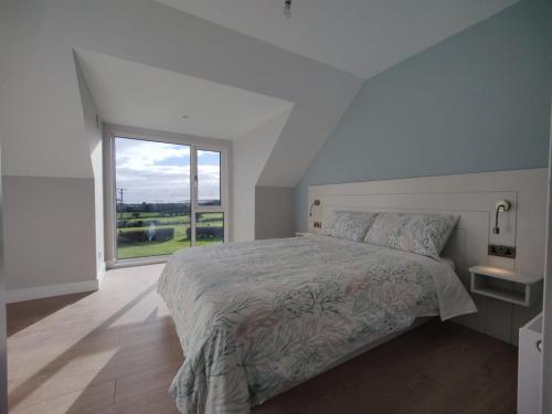a bedroom with a large bed and a large window at Lighthouse view in Garryvoe