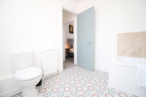 a bathroom with a toilet and a tub and a sink at Afan House by STAE-Homes in Glyncorrwg