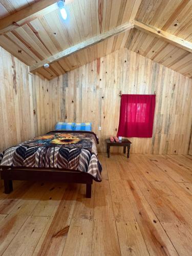 a bedroom with a bed in a wooden room at Cabaña en el Rancho in San Jose del Pacifico